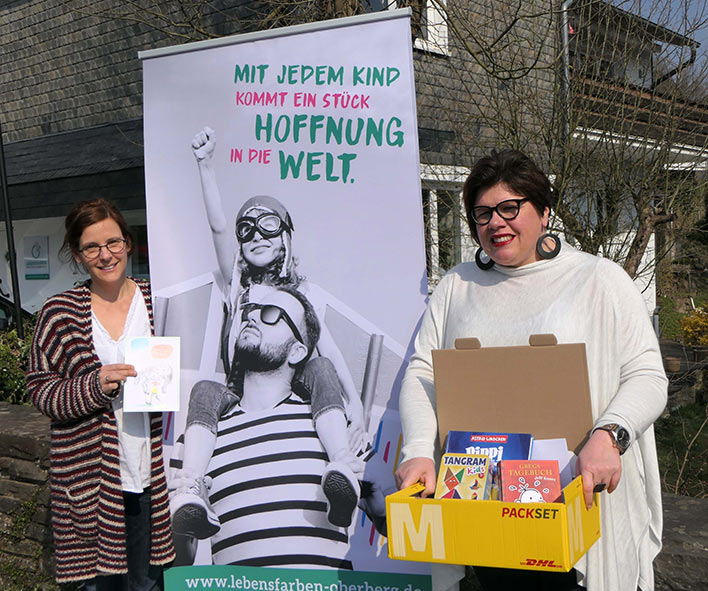 Martina Gramm und Sandra Karsten (r.) vor der Geschftsstelle in Wiehl mit einem der Pakete, die gerade bei den Familien eintrudeln. Foto: Verein Lebensfarben